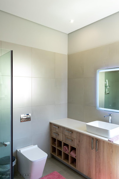Modern bathroom with timber vanity, vessel basin and LED-lit mirror