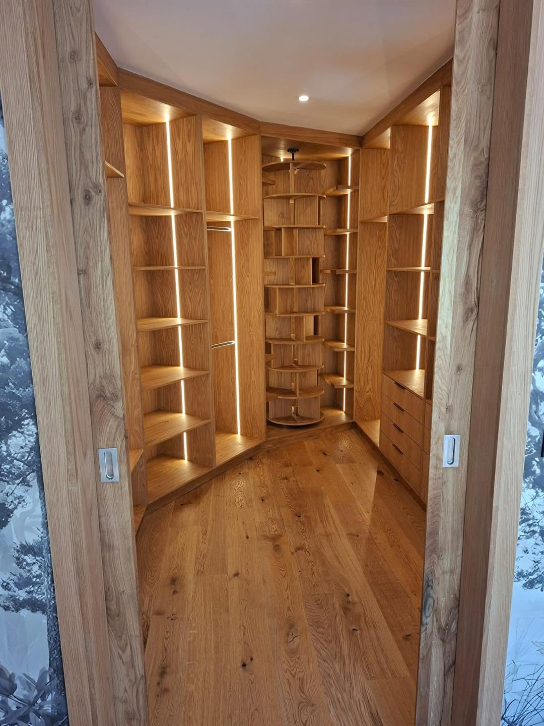 Walk-in oak dressing room with LED-lit shelving and rotating shoe rack