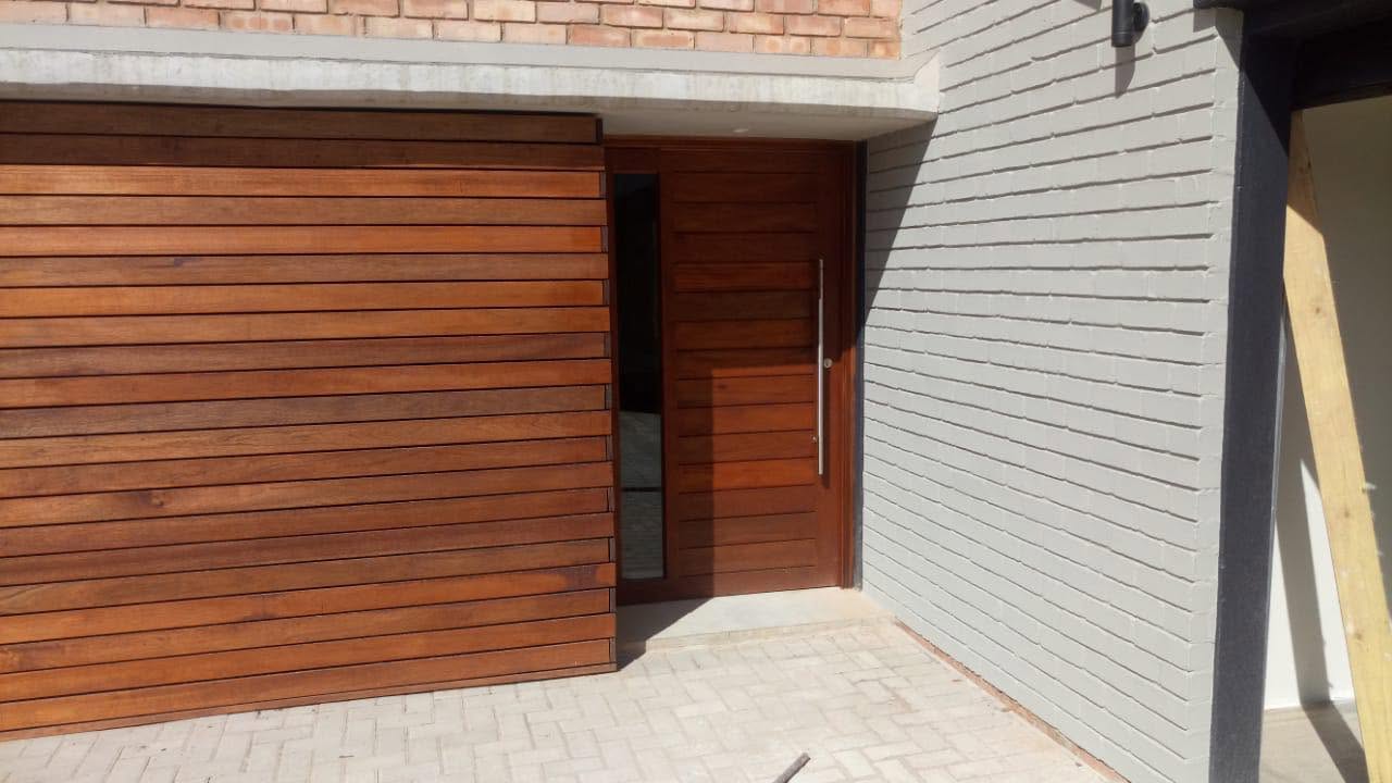 Timber-clad facade with matching pivot entrance door