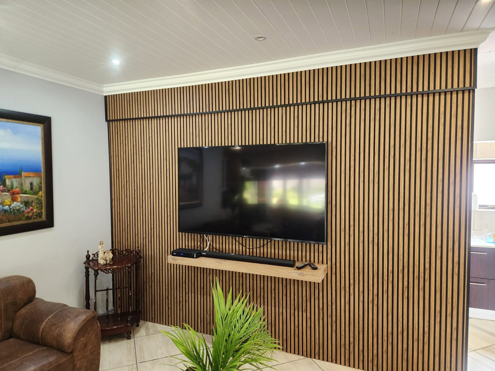 Full-wall oak slat cladding with floating TV shelf