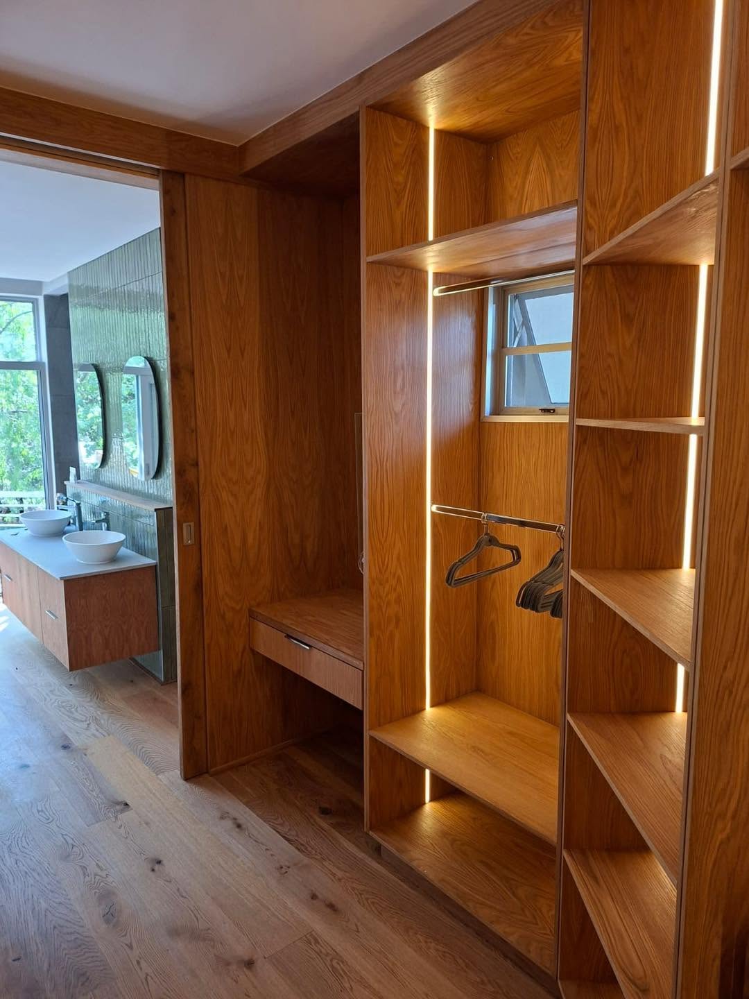Solid oak walk-in dressing area with backlit shelving