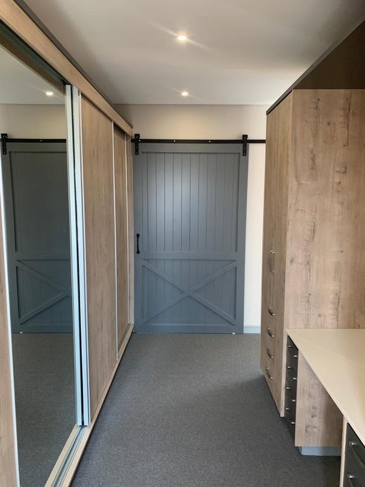 Walk-in cupboard with grey barn-style sliding door