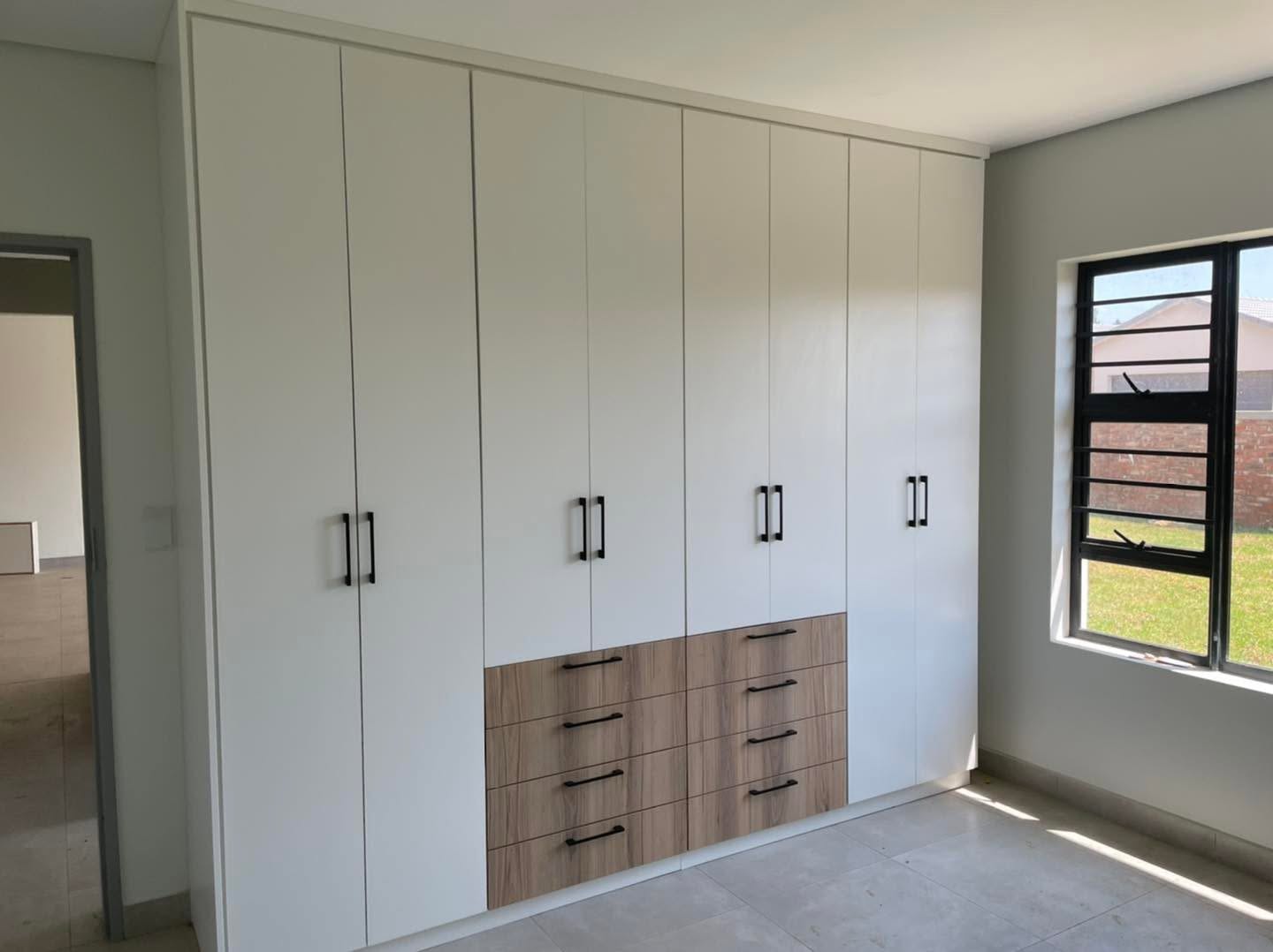 Tall white melamine cupboards with timber drawer feature