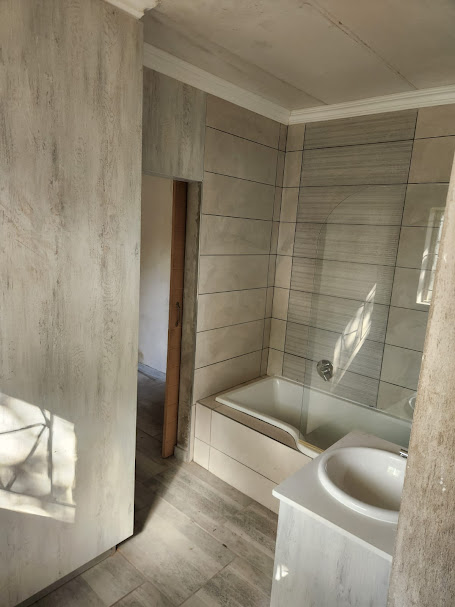 Built-in bath with timber-look tiling and frameless shower screen
